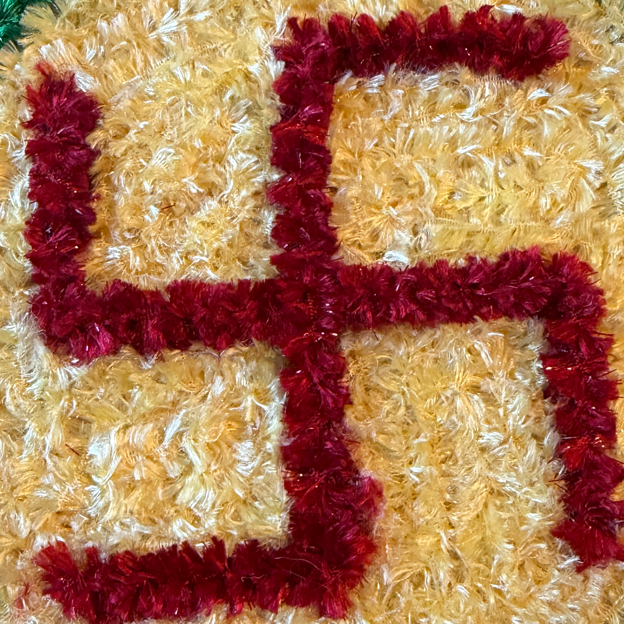 Close-up showing the original raised red Swastik and handmade golden fiber texture