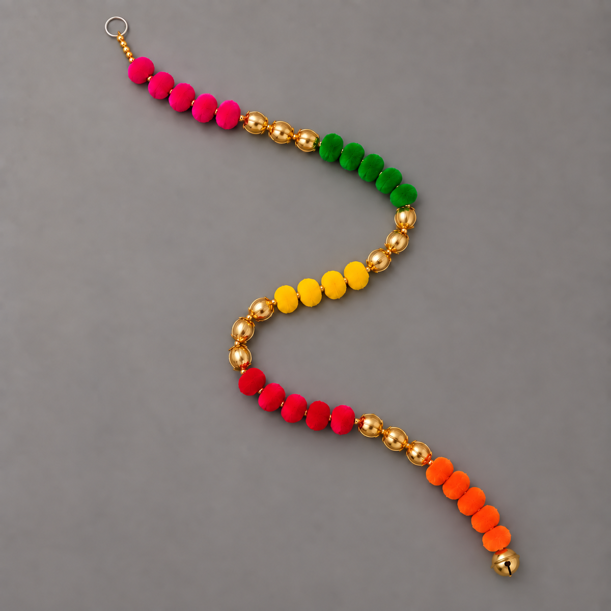 Full multicolor pom-pom hanging arranged in an S curve with loop and bell visible