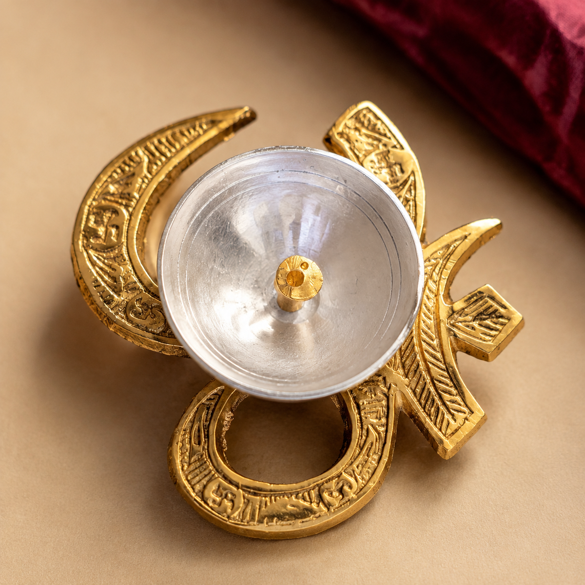 Close-up of engraved Om and Swastik motifs on festive tealight holder