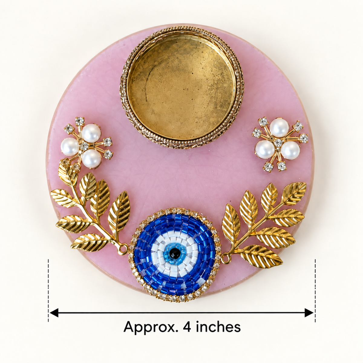 Pink evil eye resin tealight holder showing approximate 4-inch width