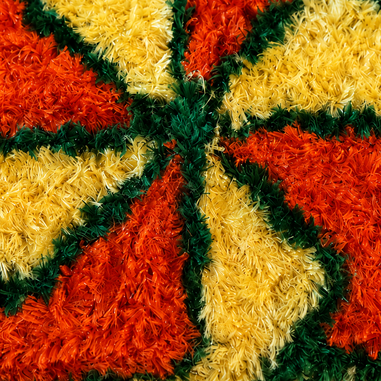 Close-up of the fuzzy handmade texture and orange yellow green pattern